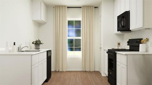 Kitchen with white cabinets, black appliances, light hardwood / wood-style floors, and sink