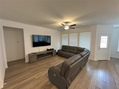 Living room with ceiling fan and light hardwood / wood-style flooring