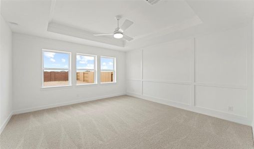 Primary bedroom with trayed ceilings and wall of windows. (*Photo not of actual home and used for illustration purposes only.)