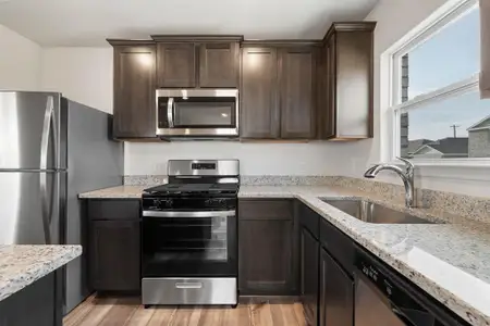 Kitchen featuring appliances with stainless steel finishes, sink, light hardwood / wood-style flooring, and dark brown cabinetry