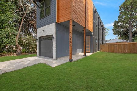 View of property exterior featuring a lawn and a garage