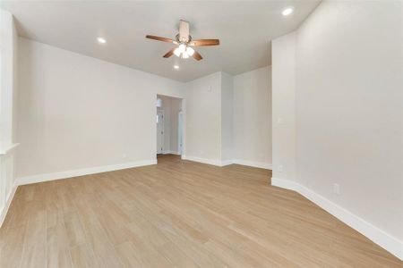 Unfurnished room with ceiling fan and light hardwood / wood-style floors