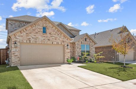 View fully bricked 2 story home and green grass