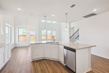 Kitchen with white cabinets, dark hardwood / wood-style flooring, an inviting chandelier, stainless steel dishwasher, and sink