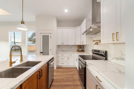 This kitchen shows off a solid white oak island with a roomy undermount sink and sleek quartz countertops. Plus, the gold accents add a luxe touch!