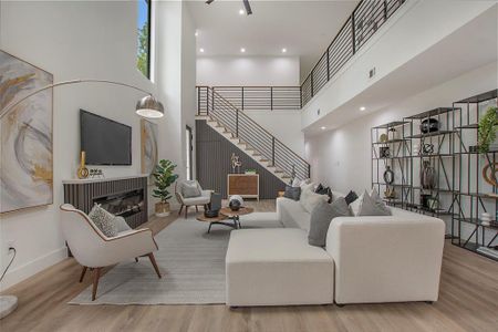 Living room with a high ceiling and light wood-type flooring