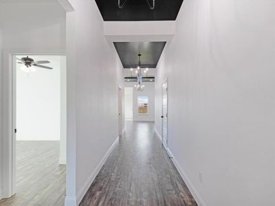 Corridor featuring a notable chandelier and hardwood / wood-style flooring