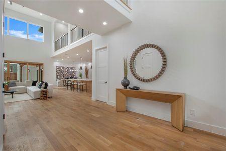 Hallway featuring a high ceiling and light hardwood / wood-style floors