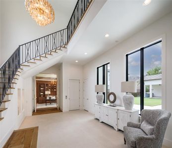 Grand foyer reception area with an Elevator. a private office, wrought iron spiral staircase and wall of windows with back yard views