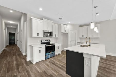 Kitchen featuring appliances with stainless steel finishes, dark hardwood / wood-style flooring, white cabinetry, and sink
