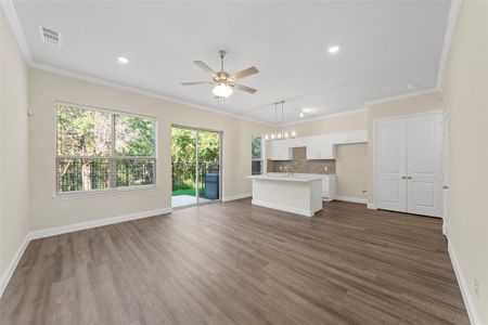 Unfurnished living room with ornamental molding, sink, ceiling fan, and dark hardwood / wood-style flooring