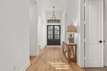 Foyer featuring a notable chandelier, light hardwood / wood-style flooring, and french doors