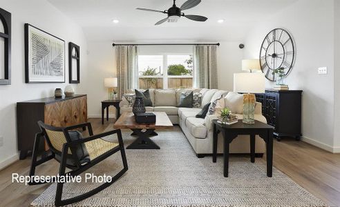 Living room with ceiling fan and hardwood / wood-style flooring