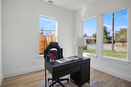 Office space with light hardwood / wood-style floors and plenty of natural light