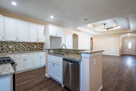 Modern white cabinets, stainless steel appliances, granite counter tops and a dishwasher in the island.