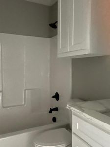 Full bathroom with shower / tub combination, vanity, and toilet