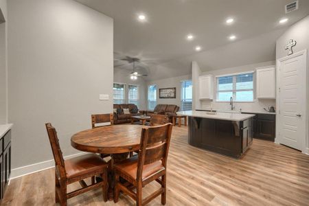 Dining space featuring lofted ceiling, ceiling fan, light hardwood / wood-style floors, and sink