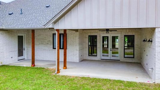 Back of property featuring a lawn, ceiling fan, a patio, and french doors