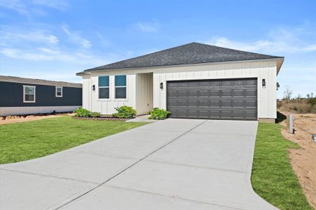 This is a modern single-story home featuring a clean design, with a two-car garage and a well-maintained front yard. The exterior is accented with contrasting trim around the windows and garage door.