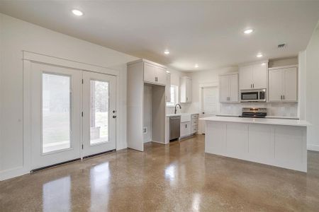 Kitchen with sink, white cabinetry, and stainless steel appliances