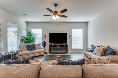 Living room with ceiling fan, hardwood / wood-style flooring, and a healthy amount of sunlight