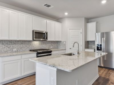 The kitchen features linen-colored cabinets and granite countertops.