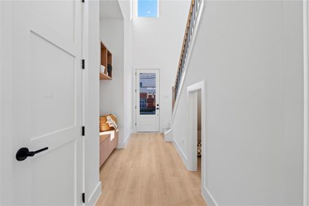 This home’s entryway seamlessly blends style with practicality. Featuring convenient shelving and an under-stair storage nook, the space provides ample room for everyday essentials—showcasing a thoughtful design where every corner is optimized for storage and function.