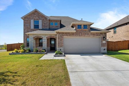 View of front of house with a garage and a front lawn