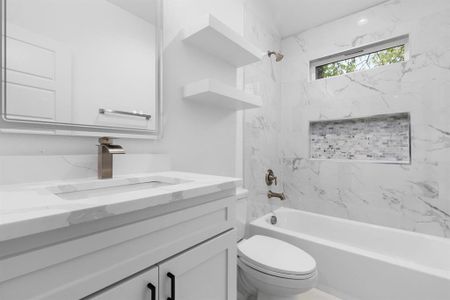 Full bathroom featuring vanity, toilet, and tiled shower / bath combo