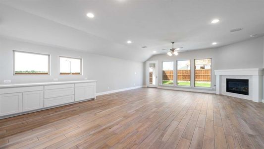 Unfurnished living room with lofted ceiling, ceiling fan, and light wood-type flooring