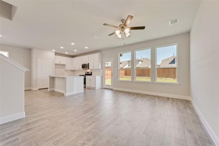 Unfurnished living room with ceiling fan, light hardwood / wood-style flooring, and sink