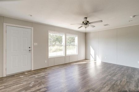 Empty room with ceiling fan, ornamental molding, and hardwood / wood-style floors