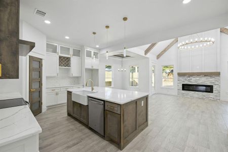 Kitchen featuring a healthy amount of sunlight, lofted ceiling with beams, dishwasher, and white cabinets