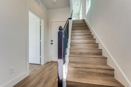 Stairs featuring hardwood / wood-style flooring