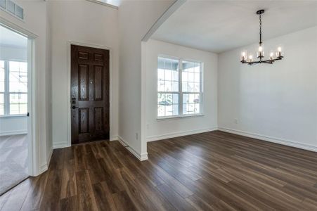 Foyer with dark hardwood / wood-style floors and a chandelier