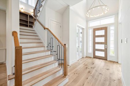 A soaring 20 ft foyer opens to a wide hallway with views through to the back yard. Wide plank wood floors continue through each space making the flow from room to room seamless.