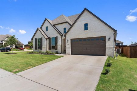 French provincial home featuring a front lawn and a garage