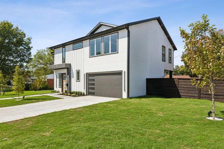 View of front of property featuring a front lawn and a garage