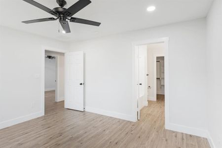 Unfurnished bedroom with light hardwood / wood-style flooring, ensuite bath, and ceiling fan