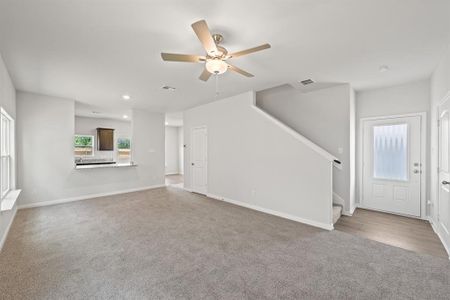 Unfurnished living room featuring ceiling fan and wood-type flooring