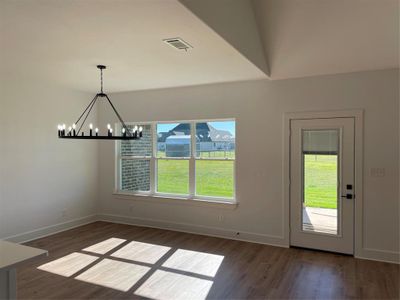 Unfurnished dining area with a chandelier and dark hardwood / wood-style flooring