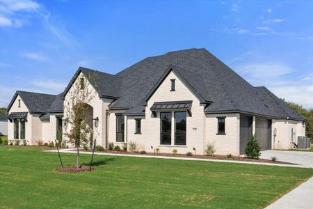 French country inspired facade with a garage, a front lawn, and central AC unit