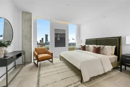 The primary bedroom is a sanctuary of modern luxury and scenic beauty. Floor-to-ceiling glass panels frame stunning panoramic views, creating a tranquil and visually striking environment. *Linden Residence No. 2107 Furnished Model Shown Here