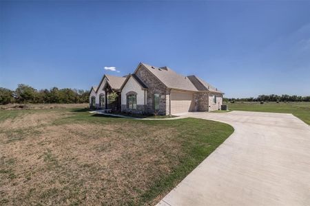 View of front of house featuring a front yard, a garage, and central air condition unit