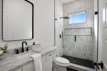 Bathroom featuring vanity, toilet, and a shower with shower door