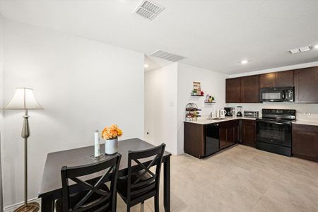 Kitchen featuring dark brown cabinetry, black appliances, and sink