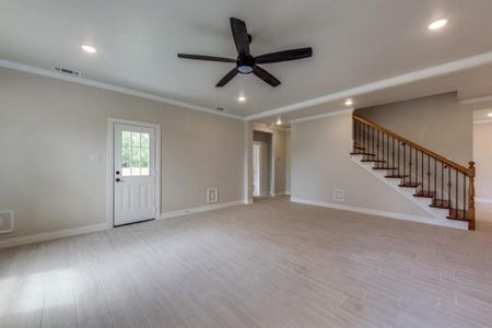 Unfurnished living room with ornamental molding and ceiling fan