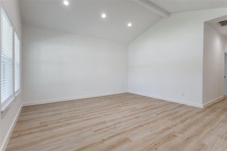 Unfurnished room with vaulted ceiling with beams and light hardwood / wood-style flooring