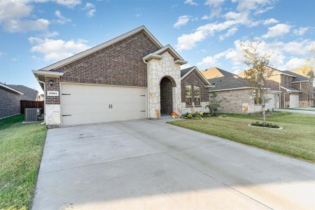 View of front of house with a front lawn, central AC, and a garage