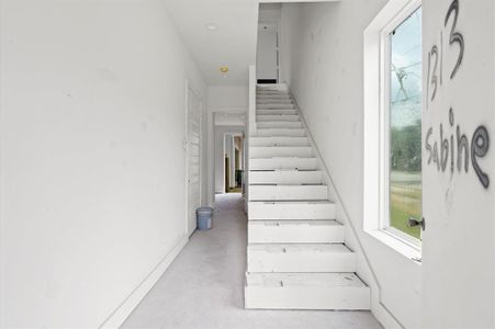 Entry way leading to first floor secondary bedroom and up to second floor kitchen and living area